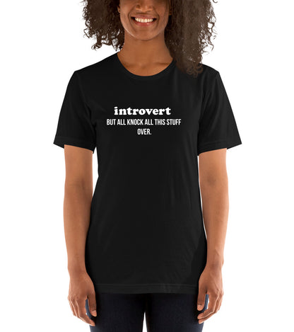 Person wearing a black t-shirt with 'introvert BUT ALL KNOCK ALL THIS STUFF OVER.' text.