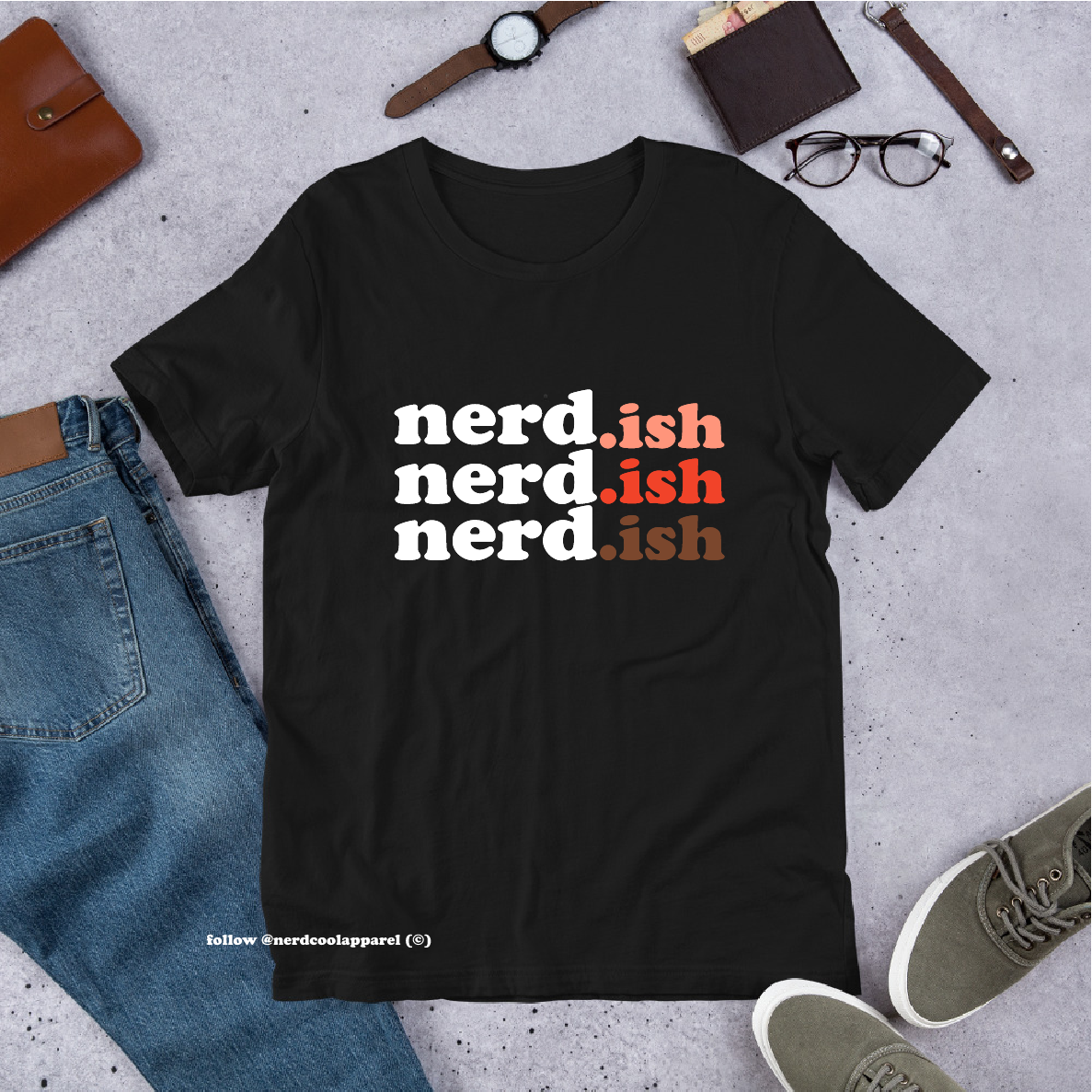 Black t-shirt with 'nerd-ish' text on a concrete surface with casual items around