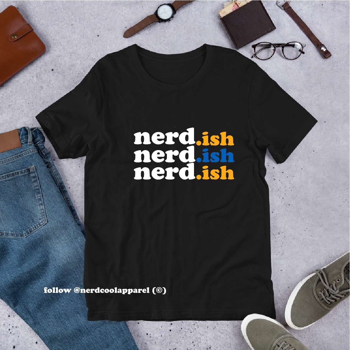Black t-shirt with 'nerd.ish' text in different colors on a gray surface with casual items.