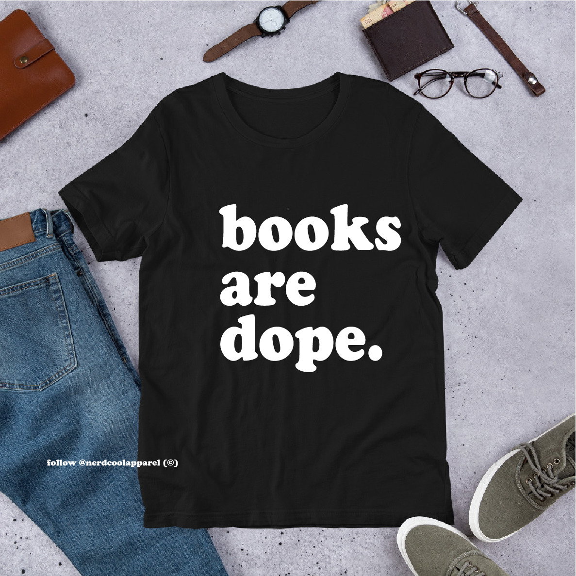 Black t-shirt with 'books are dope.' text on a gray surface with jeans, shoes, and accessories.