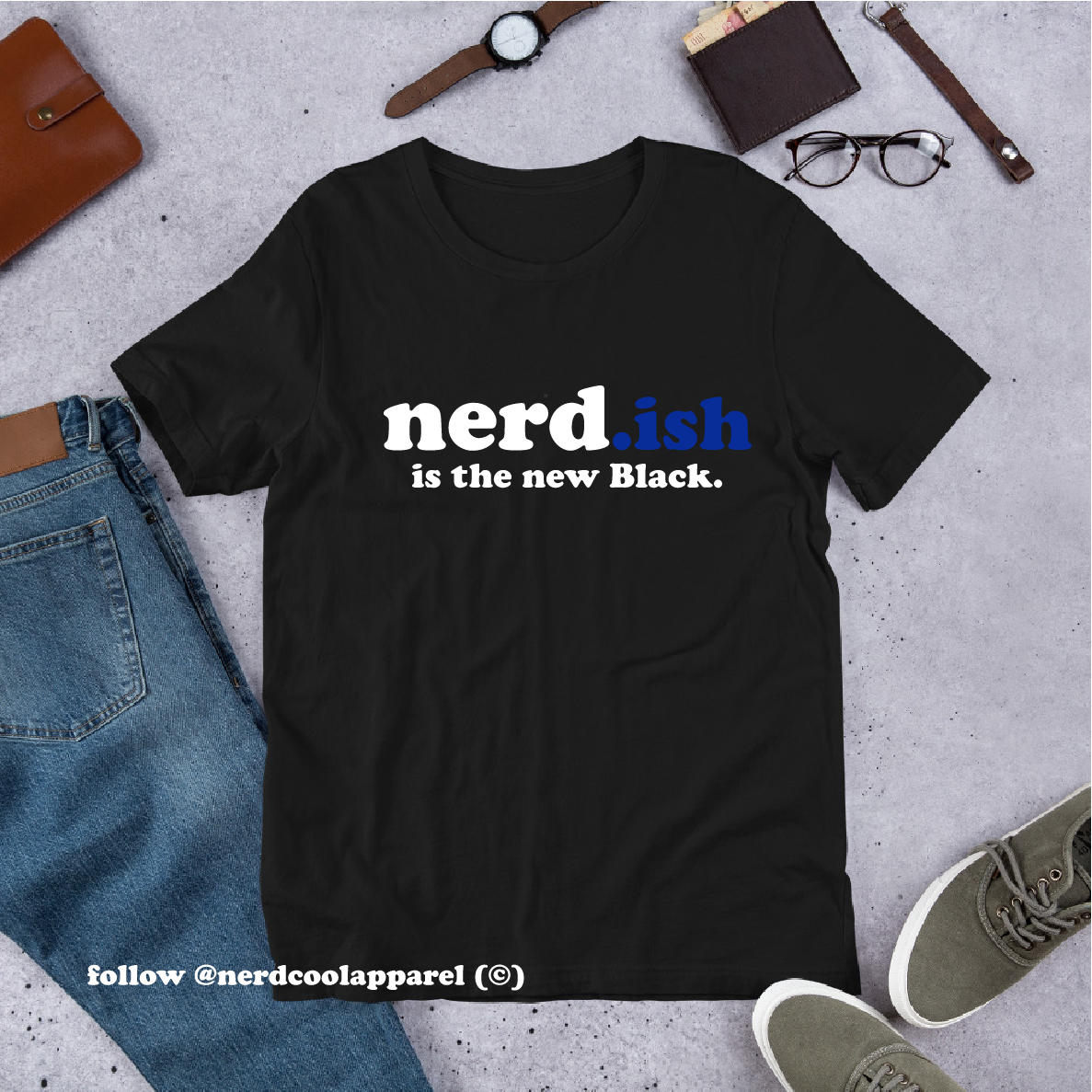 Black t-shirt with 'nerd.ish is the new Black' text on a gray surface with jeans, shoes, and accessories.