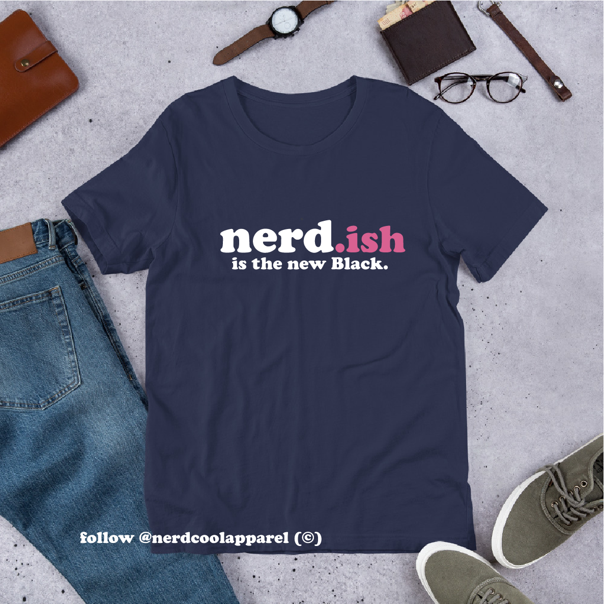 Navy blue t-shirt with 'nerd.ish is the new Black' text on a gray surface with jeans, shoes, and accessories.