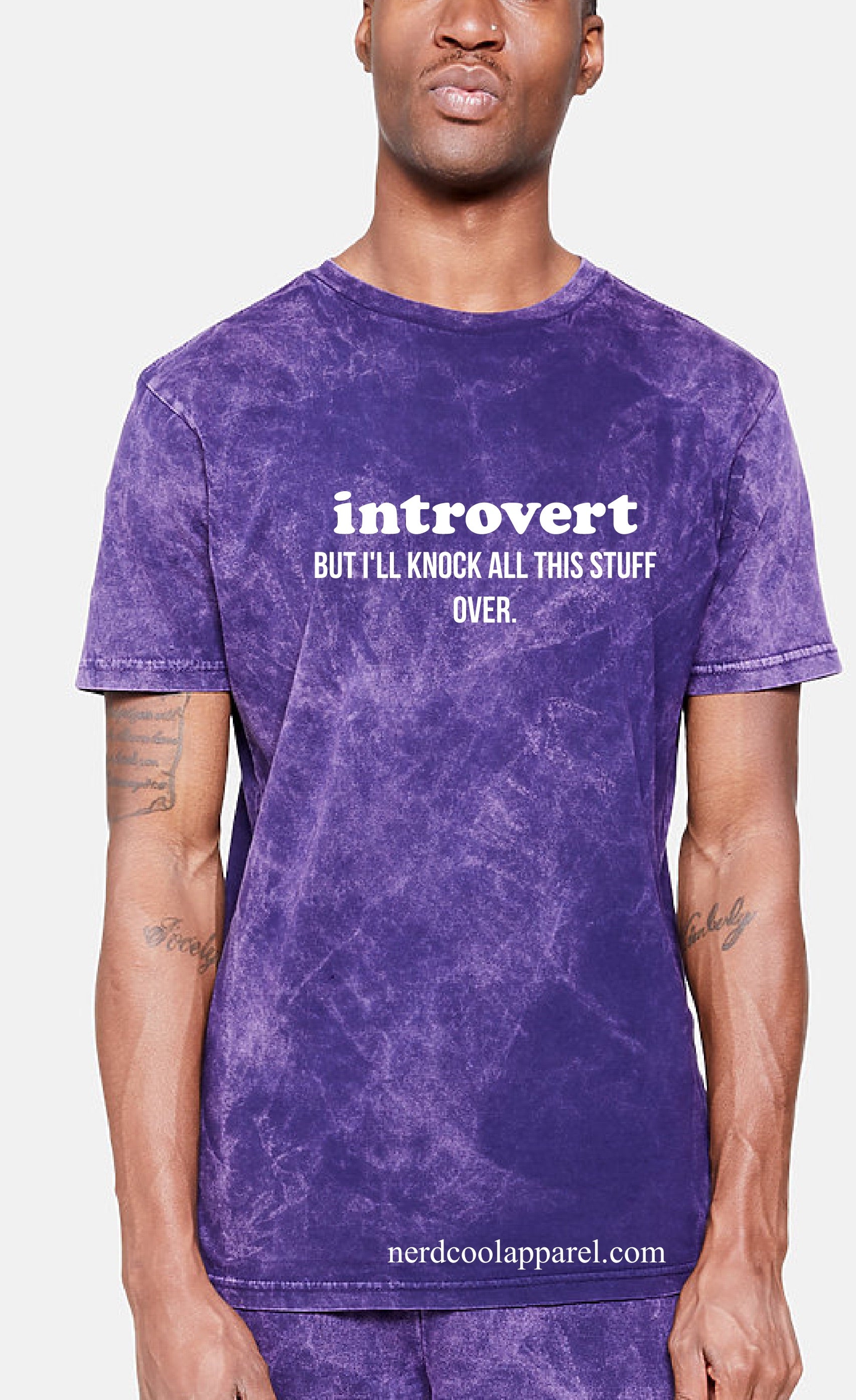 Person wearing a purple t-shirt with text 'introvert BUT I'LL KNOCK ALL THIS STUFF OVER' on a white background