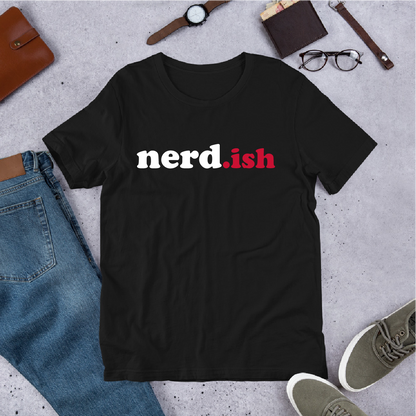 Black t-shirt with 'nerd.ish' text on a concrete surface with jeans, shoes, and accessories.