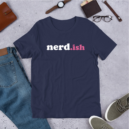 Navy blue t-shirt with 'nerd.ish' text on a concrete surface with jeans, shoes, and accessories.