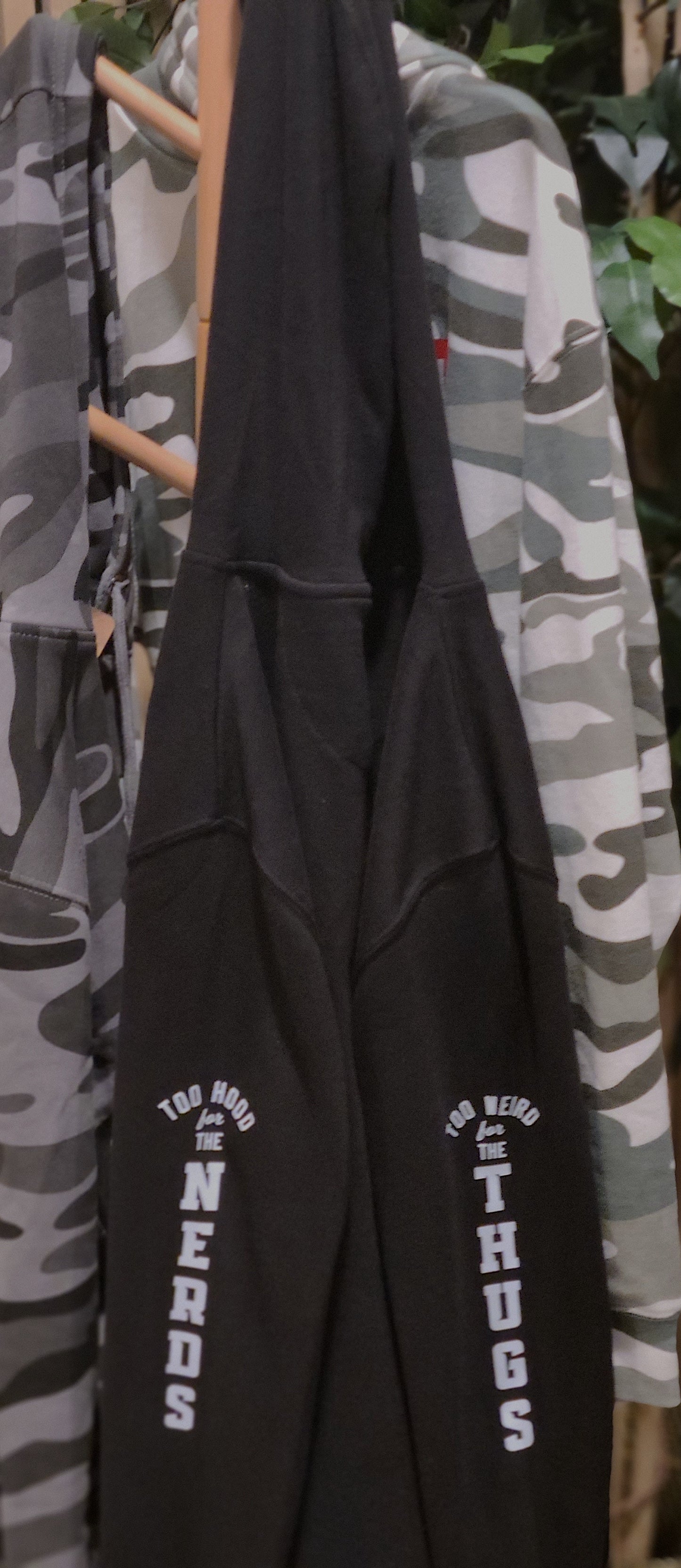 Black hoodie with text on a rack with camouflage jackets