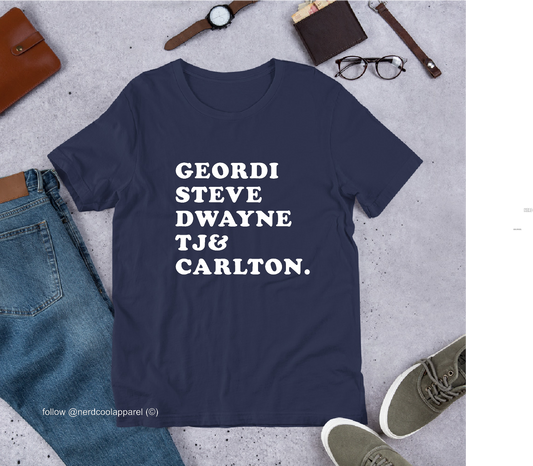 Navy blue t-shirt with white text on a gray surface with casual items around