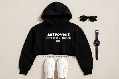 Black hoodie with 'introvert' text, white sneakers, sunglasses, and watch on a beige background
