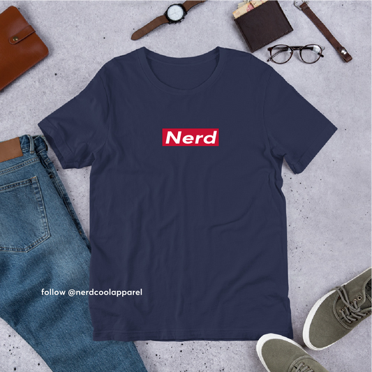 Navy blue t-shirt with 'Nerd' logo on a gray surface with jeans, shoes, and accessories.