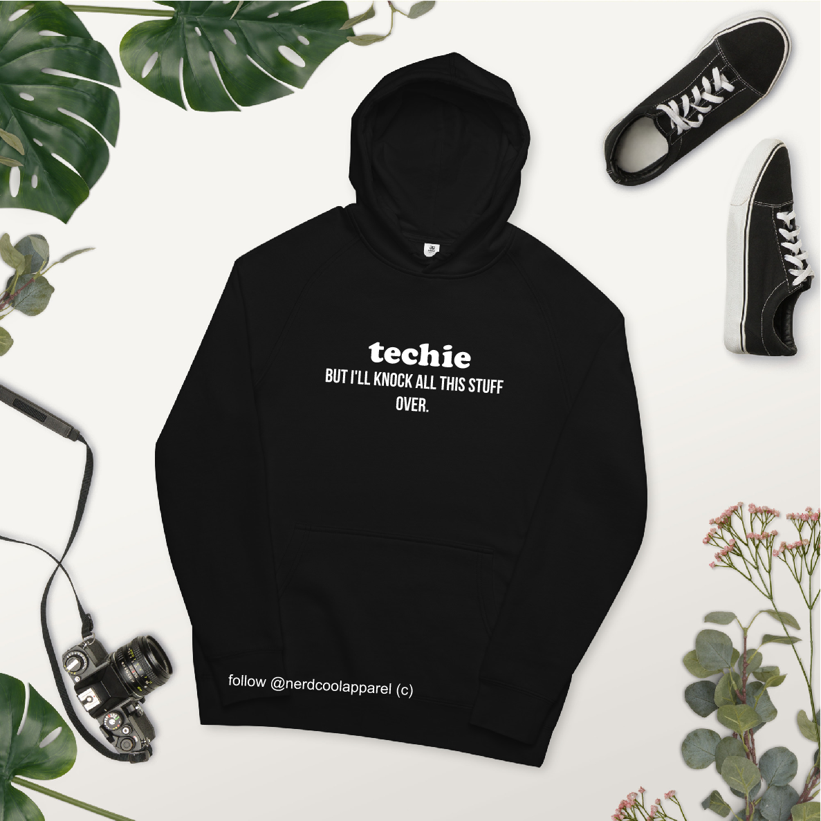 Black hoodie with text, surrounded by plants and shoes on a white background