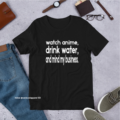 Black t-shirt with text 'watch anime, drink water, and mind my business' on a gray surface with casual items.